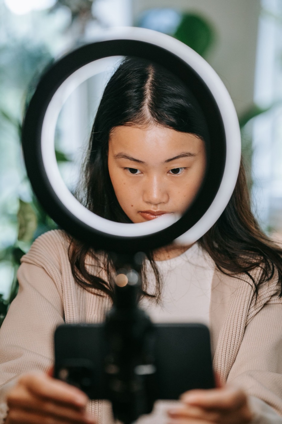 A young woman recording content with a ring light